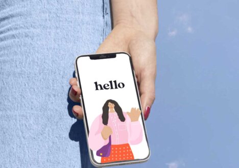 Woman holding an iphone against a blue sky