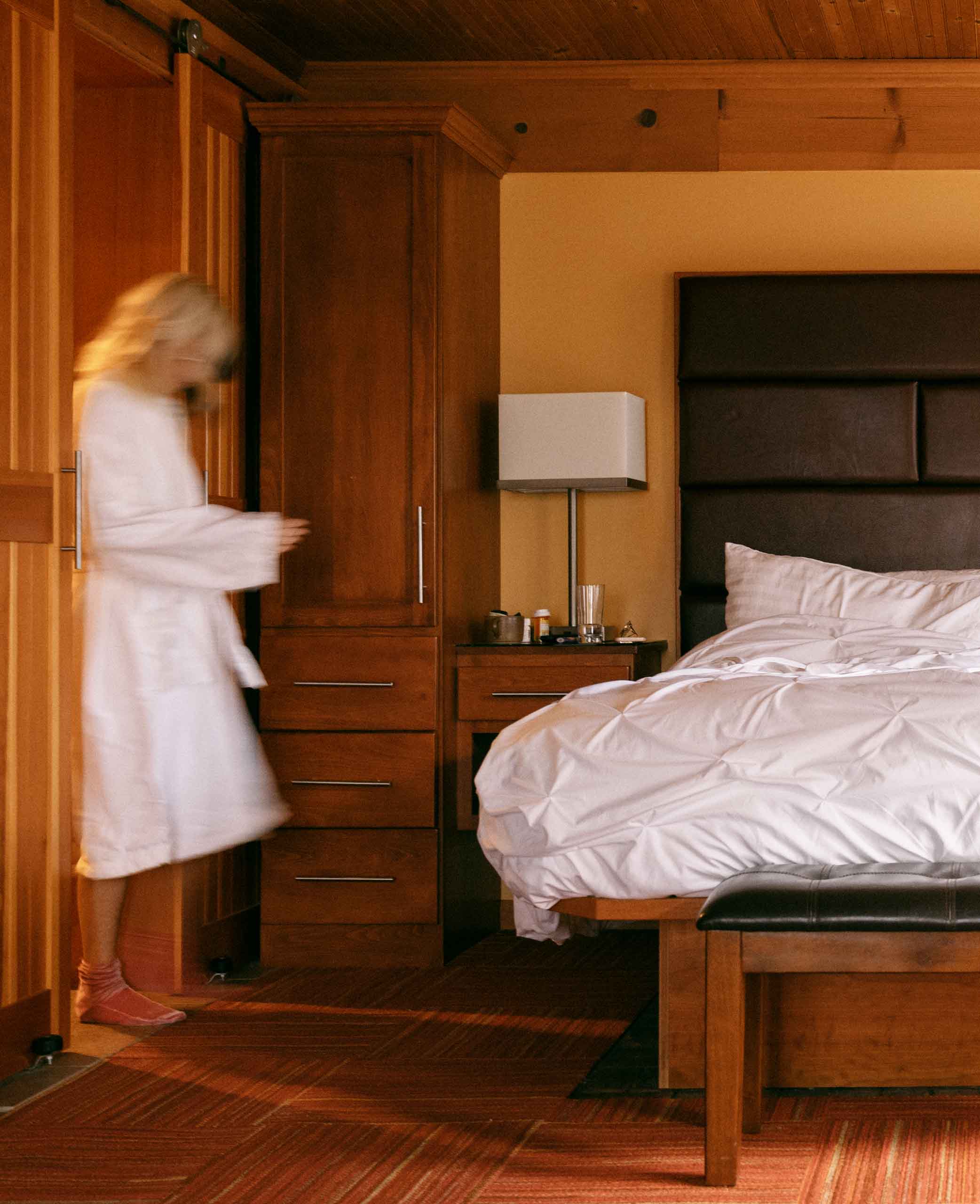 Woman in a robe entering a hotel room