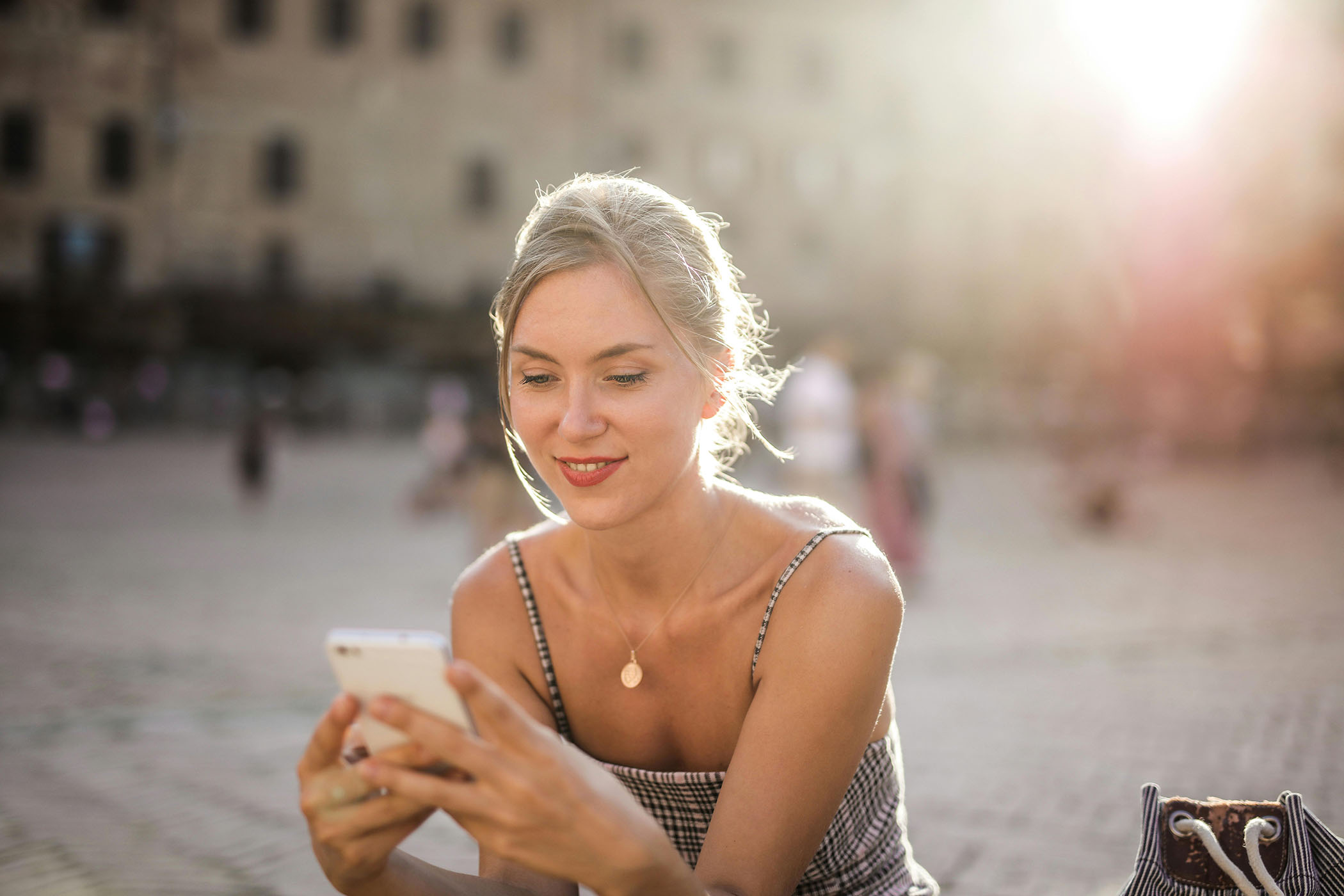Woman sitting outside looking at phone