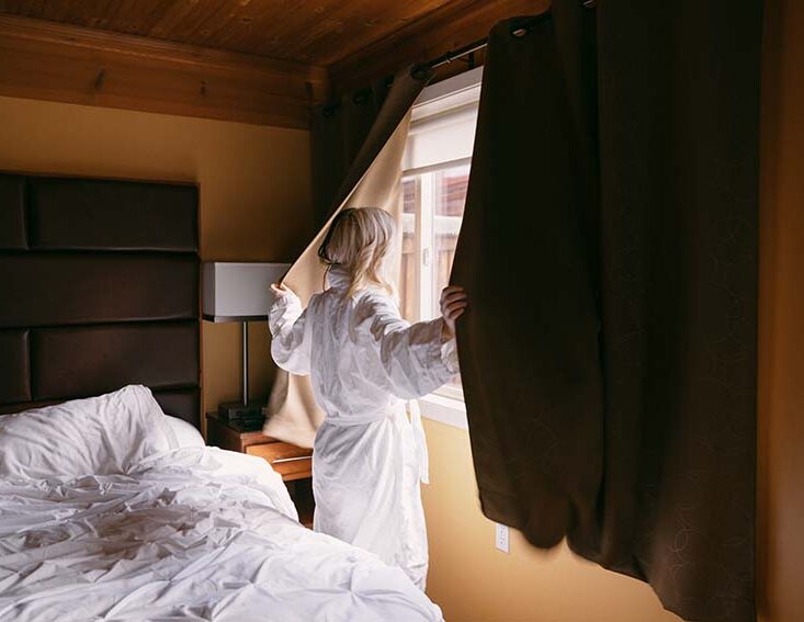Woman looking out hotel window