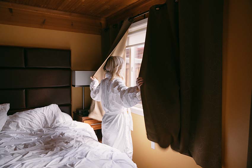 Woman looking out hotel window